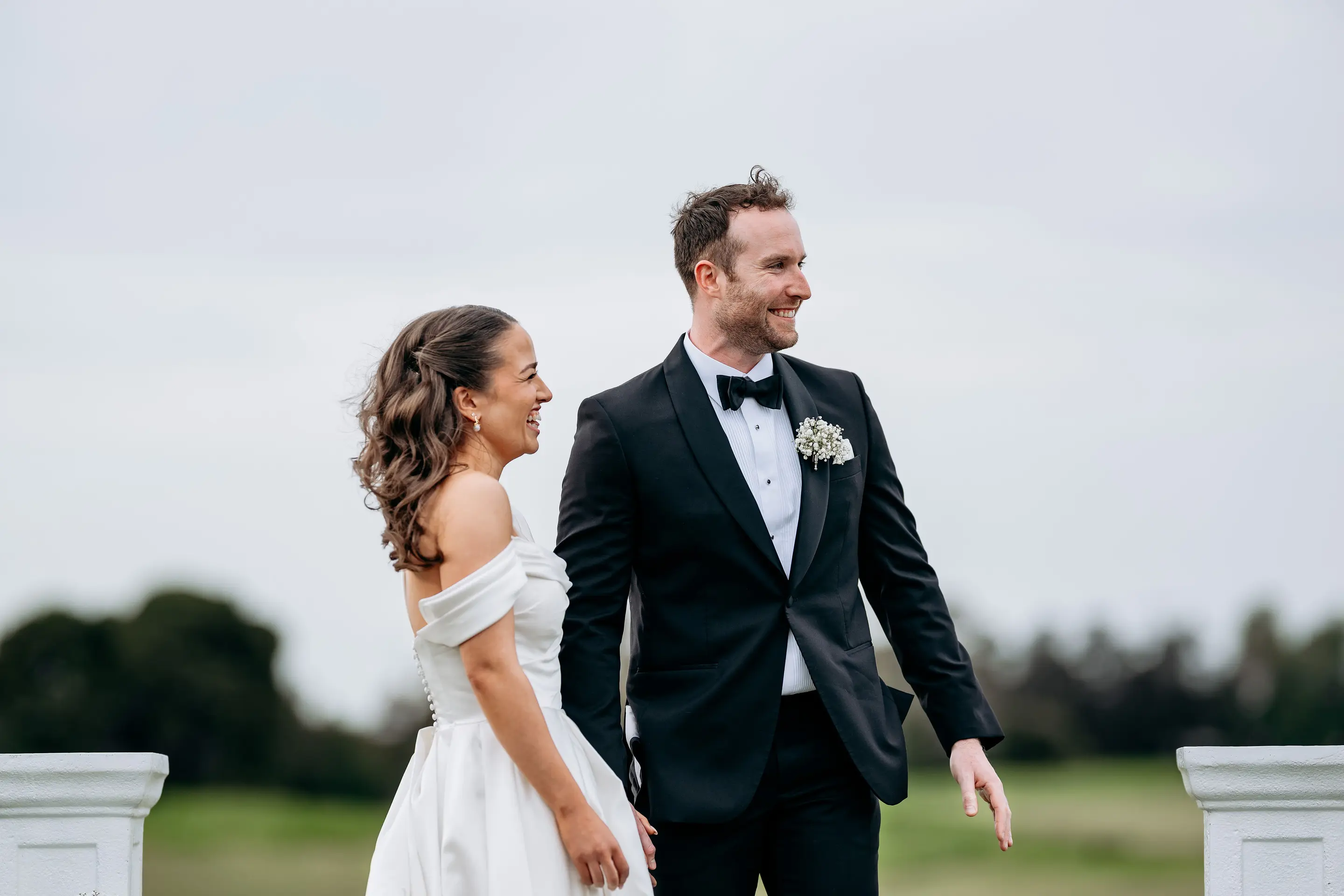 Henry and Elise, who built WedBuild, smiling at each other at their wedding ceremony