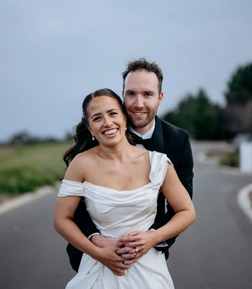 Elise and Henry on their wedding day, his arms around her, both laughing